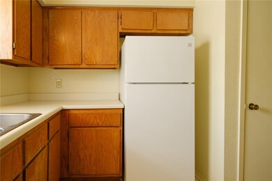 Kitchen with brown cabinets, light countertops, an