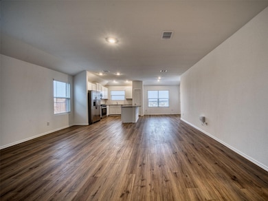 Unfurnished living room with baseboards, dark woo