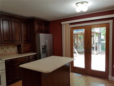 Kitchen has double doors that lead to the back yar