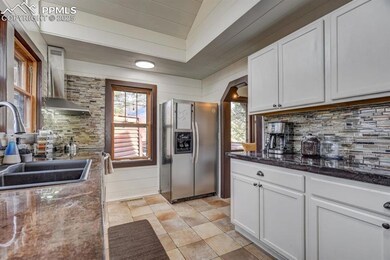 Kitchen featuring white cabinetry, stainless steel