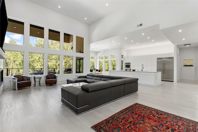 Living area with a high ceilings, commercial grade, luxury vinyl flooring, LED flush mount with high efficiency puck lights, and a glass covered propane fireplace, & 85