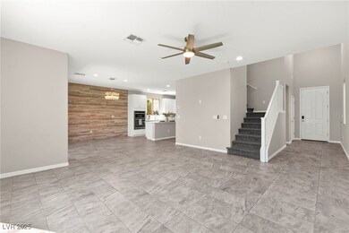 Unfurnished living room with stairs, ceiling fan,
