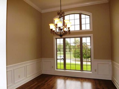 The formal dining room is located to the right of the foyer and opens to the living room. The high ceiling accentuates the two story arched window. 