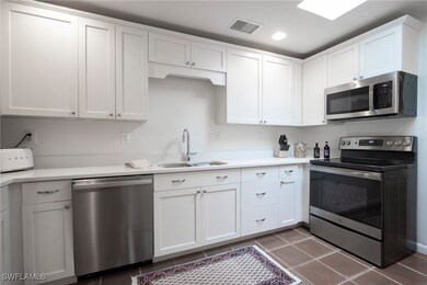 Kitchen featuring white cabinets, appliances with
