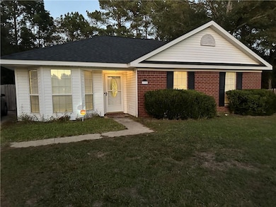 View of front of property featuring a front lawn, roof with shingles, and brick siding