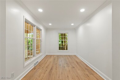 Empty room featuring crown molding, light wood-style floors, and recessed lighting