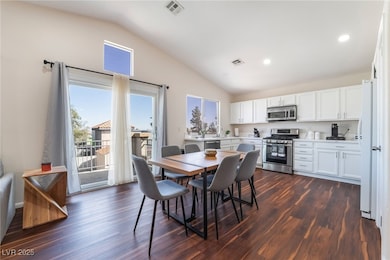 Dining area with vaulted ceiling, dark wood-style