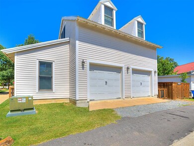 View of side of property with a garage and a lawn