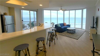 Living room featuring a water view, a wall of wind
