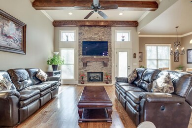 Spacious Family Room with Thick Cut 12 ft Cedar Stained Beams and Floor to Ceiling Gas Fireplace