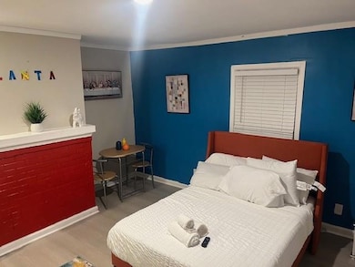 Bedroom featuring wood finished floors, baseboards, and crown molding