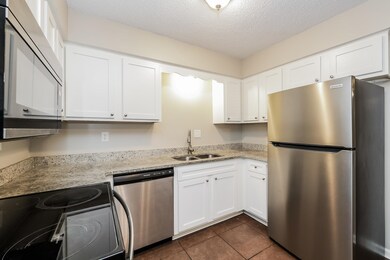 Kitchen featuring light stone counters, a textured
