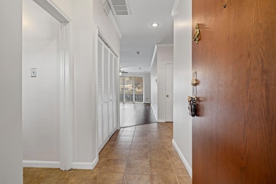 Hall featuring crown molding and light tile patter