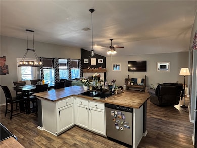 View of the kitchen facing the living room, showcasing a center island and a cozy freestanding breakfast nook.
