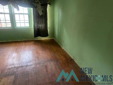 Spare room with dark wood-style floors and baseboards