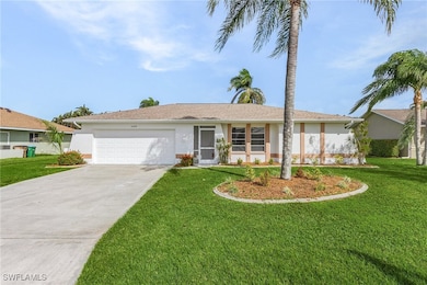 Single story home featuring a garage and a front y