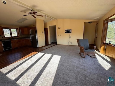 Unfurnished room with vaulted ceiling, rail lighti