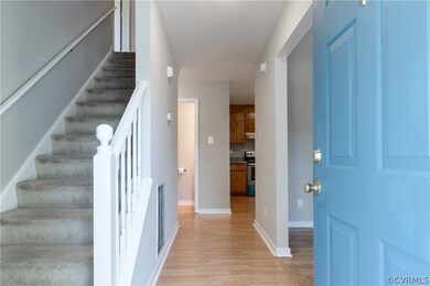 The foyer has laminate wood flooring, storm door,