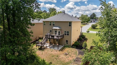 Back of property featuring a yard, a deck, a patio
