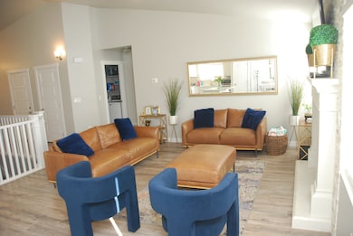 Living room featuring wood finished floors and vaulted ceiling