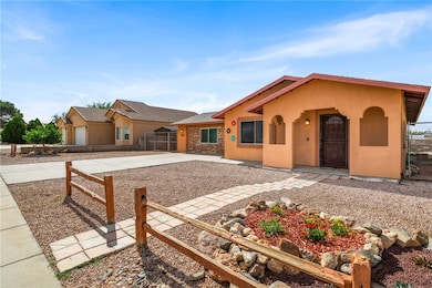 View of front of home featuring stucco siding, driveway, and stone siding