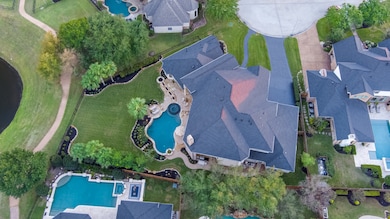 The lawn is impeccably maintained with manicured shrubs and border detail that echoes the home’s elegance.