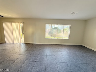 Spare room with baseboards and tile patterned flooring