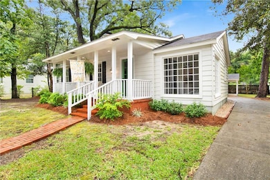 View of front facade with covered porch, roof with shingles, and driveway