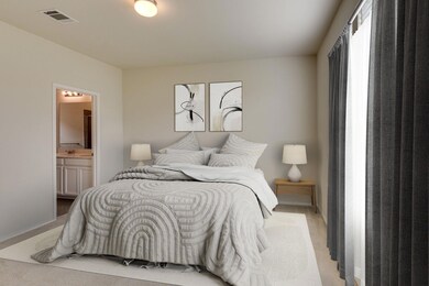Bedroom featuring light colored carpet and ensuite