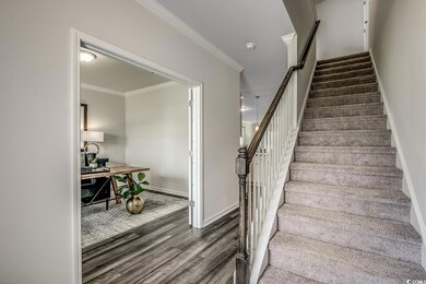 Stairway featuring wood finished floors, ornamental molding, and baseboards