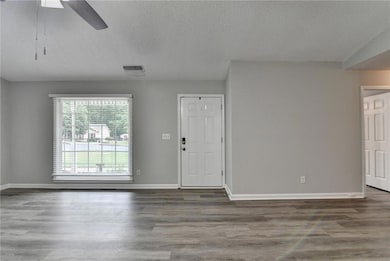 Unfurnished living room featuring a textured ceili
