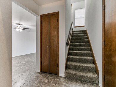 Stairway featuring ceiling fan and tile floors