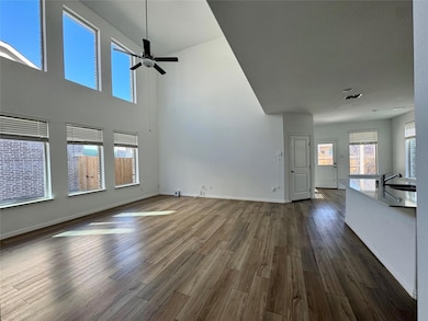 Unfurnished living room featuring a sink, baseboar