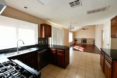 This is a two-story, traditional-style home featuring a tan brick exterior, an attached two-car garage, and a blue front door. The house has a well-maintained lawn and is situated in a suburban neighborhood.