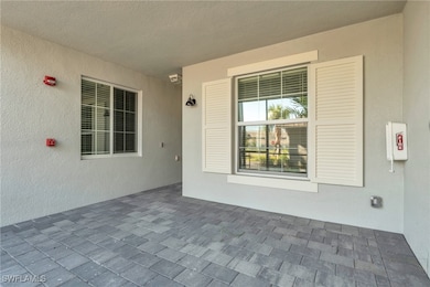 Entrance to property with stucco siding and a patio