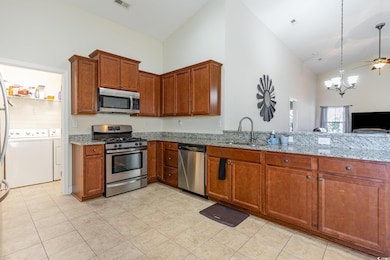 Kitchen with light stone counters, brown cabinets,