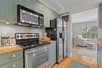 Kitchen featuring light stone counters, green cabi