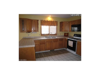 Fully applianced kitchen with tile floor.