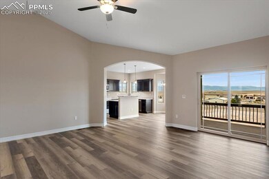 Unfurnished living room with baseboards, arched wa