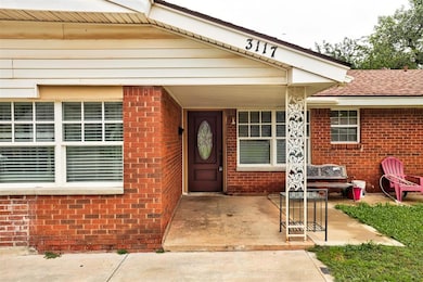 Doorway to property with brick siding and roof with shingles