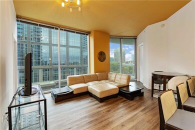Living room featuring floor to ceiling windows, a city view, and wood finished floors