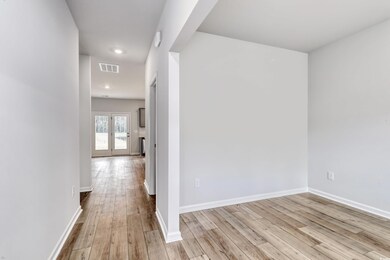 Corridor with light wood-type flooring, baseboards