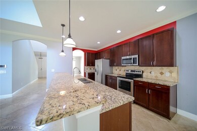 Kitchen featuring hanging light fixtures, stainless steel appliances, light stone counters, tasteful backsplash, and light tile flooring