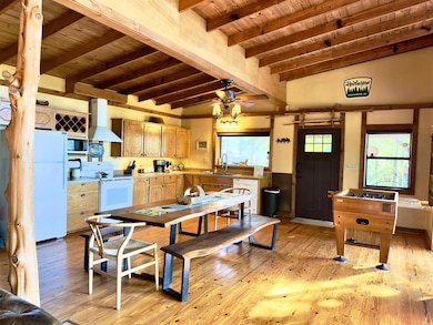 Dining area featuring healthy amount of natural light, wooden ceiling, light wood-style floors, and a ceiling fan