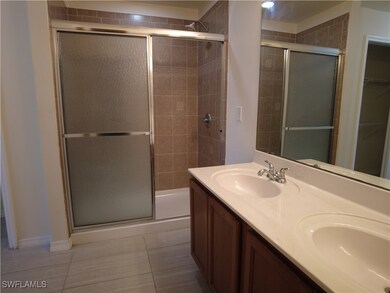 Bathroom with dual vanity, tile patterned floors,