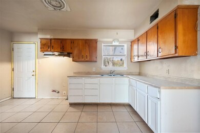 Kitchen featuring white cabinetry, sink, and light