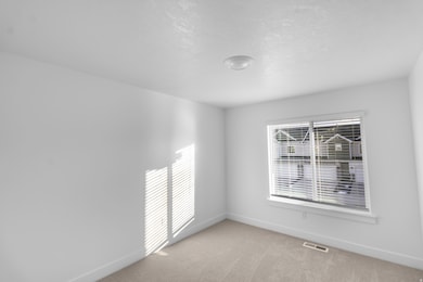 Spare room with light colored carpet and a textured ceiling