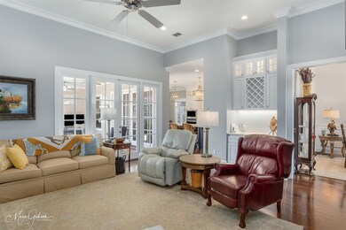 Living room with crown molding, ceiling fan with n