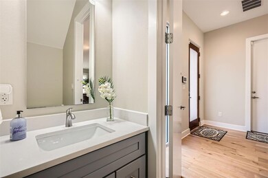 Bathroom with wood finished floors, vanity, reces