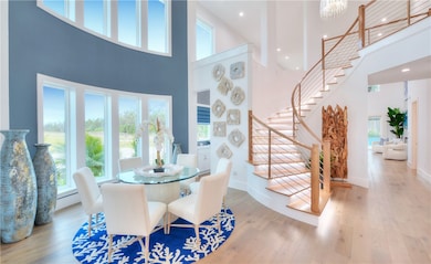 Dining area with stairway, wood-type flooring, a high ceiling, recessed lighting, and baseboard heating